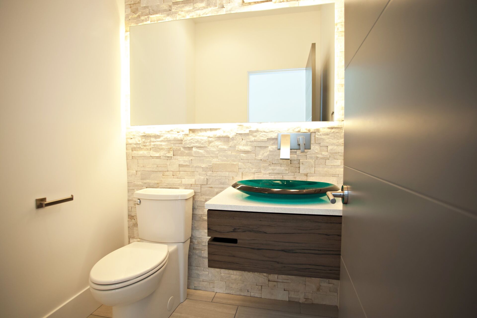 A bathroom with a toilet , sink and mirror.
