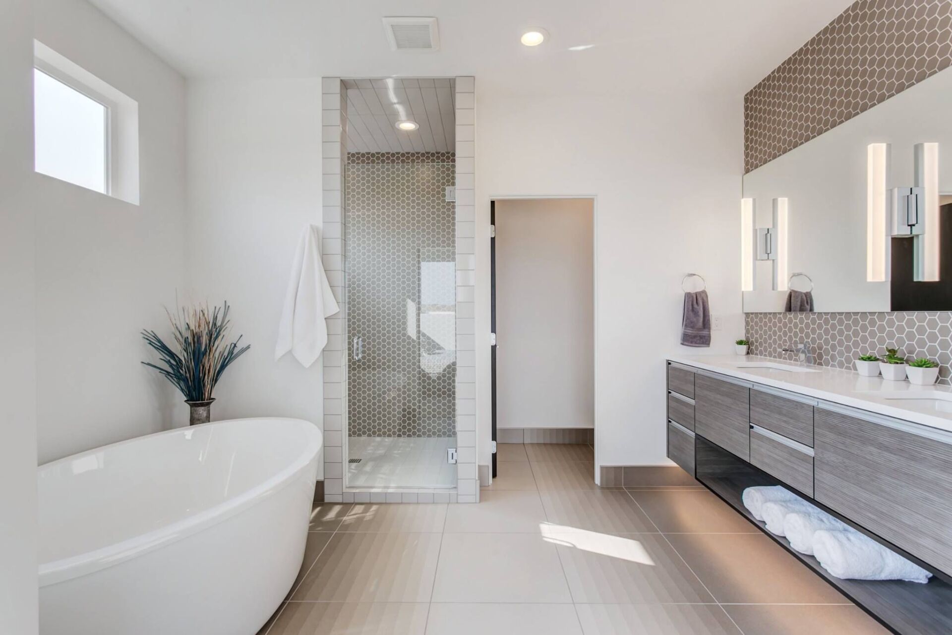 A bathroom with a tub , sink , mirror and walk in shower.