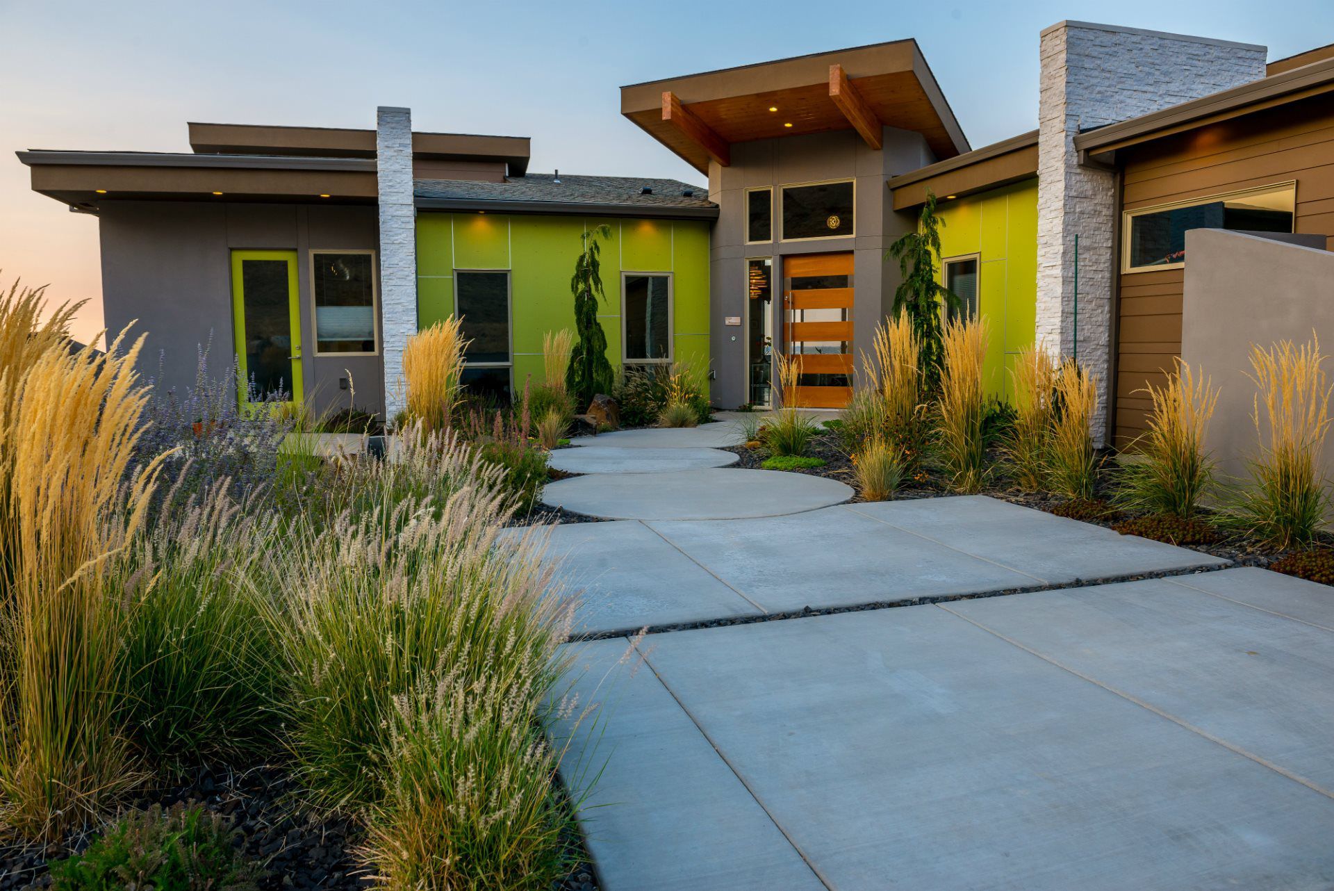A modern house with a concrete driveway leading to it.