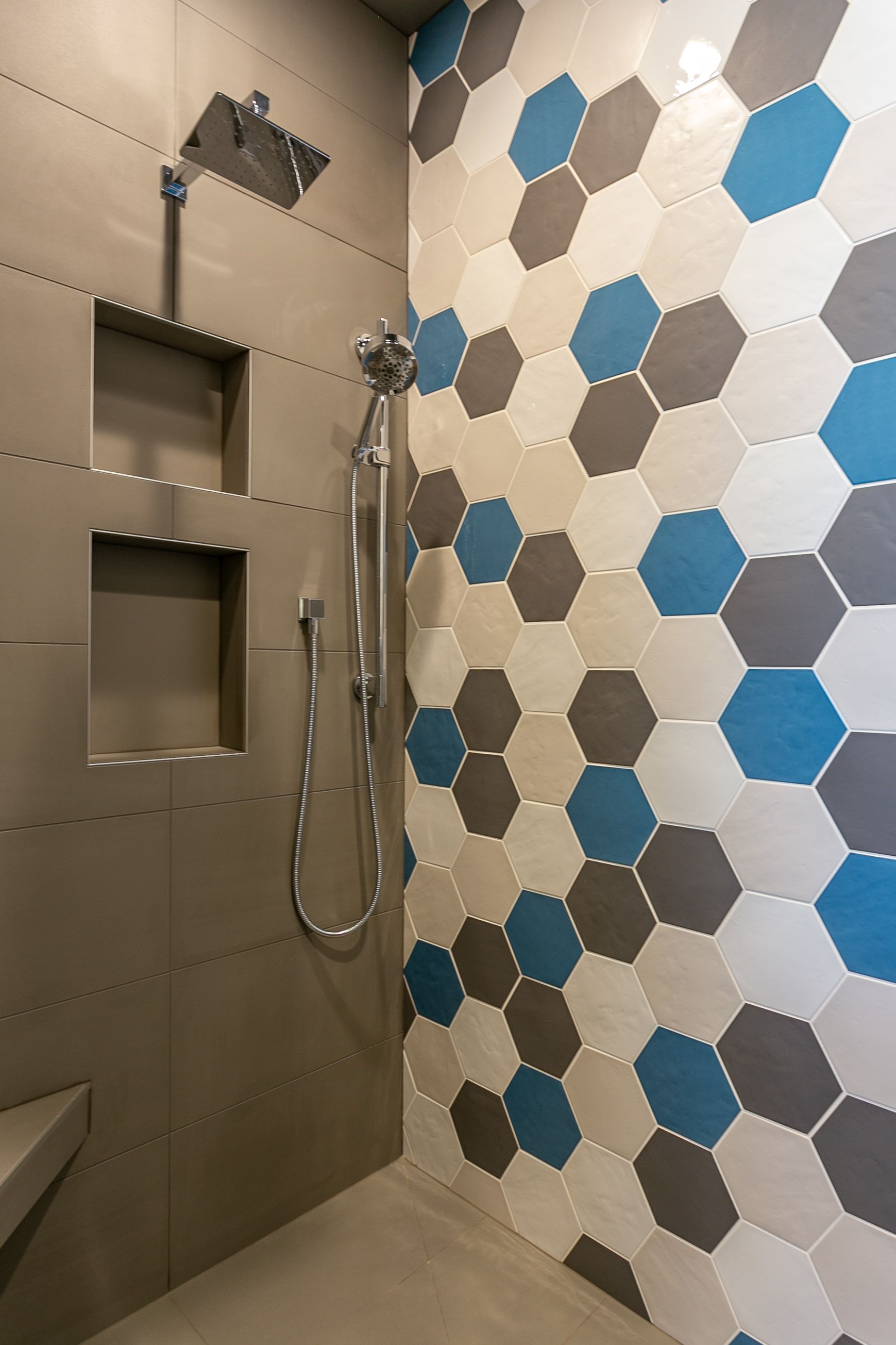 A shower with hexagonal tiles on the wall and a shower head.