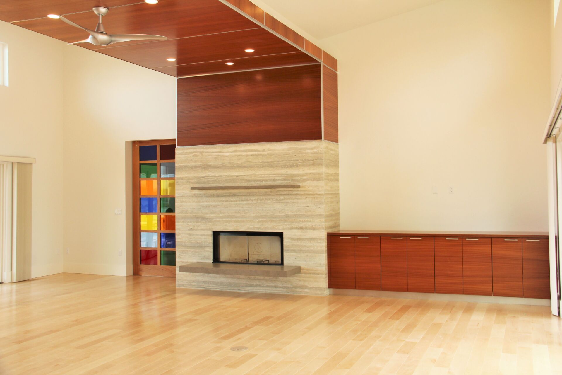 A living room with a fireplace and a ceiling fan