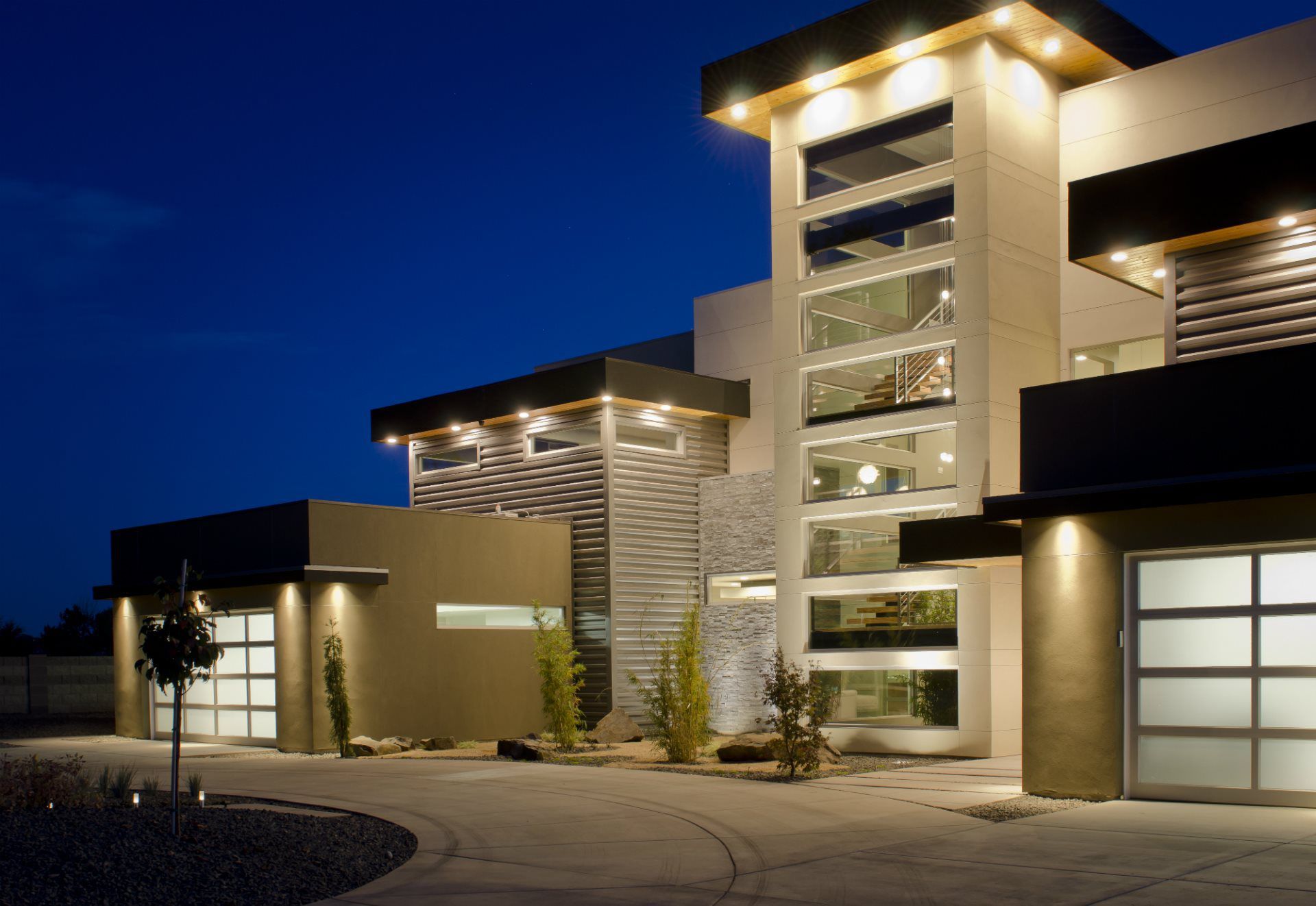 A large house with a lot of windows is lit up at night
