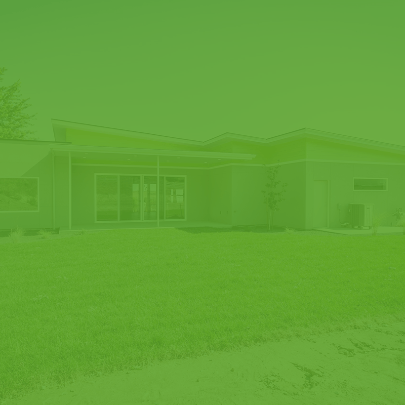A green background of a house with a large lawn in front of it.