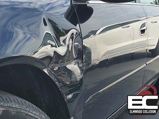 Vehicle with dents in fender and door at Elmwood Collision