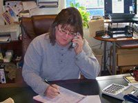 Tina, sitting at her desk answering the phone Tina, sitting at her desk answering the phone