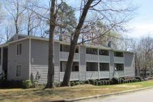 Featherstone Apartments Two-story gray apartment building with fenced-in balconies