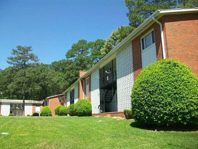 Two-story brick apartment building surrounded by a nicely landscaped lawn