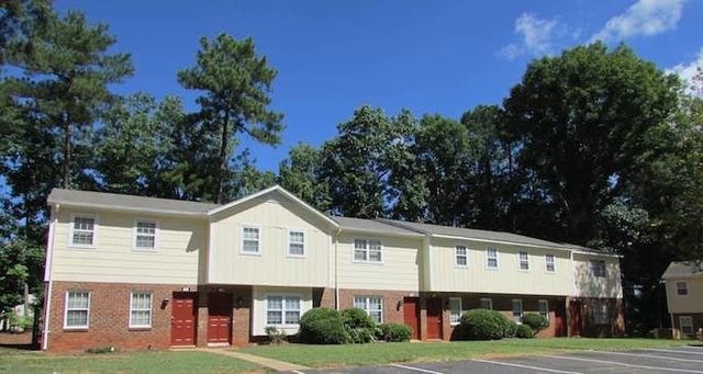 Two-story apartment building with yellow siding/brick exterior
