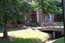 Plaza Apartments (Greenville Drive) Two-story, brick apartment buildings surrounding by trees
