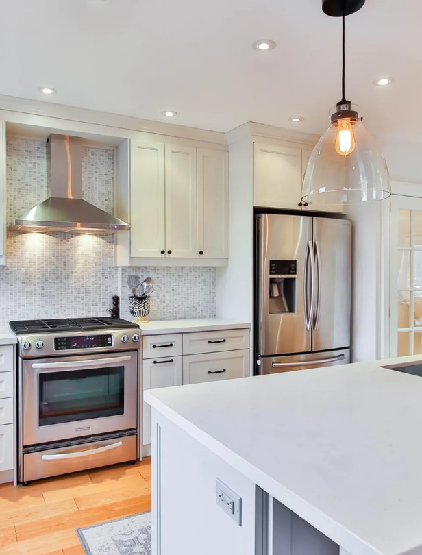 A kitchen with stainless steel appliances and white cabinets