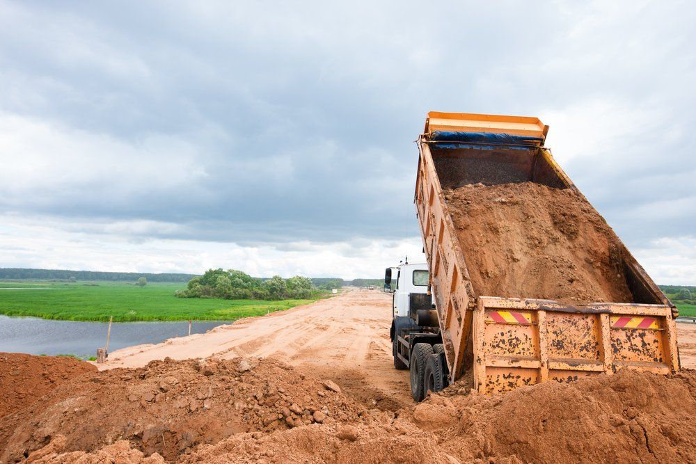 Truck Unloading Soil Or Sand At Construction — Northern Demolition and Civils in Garbutt, QLD