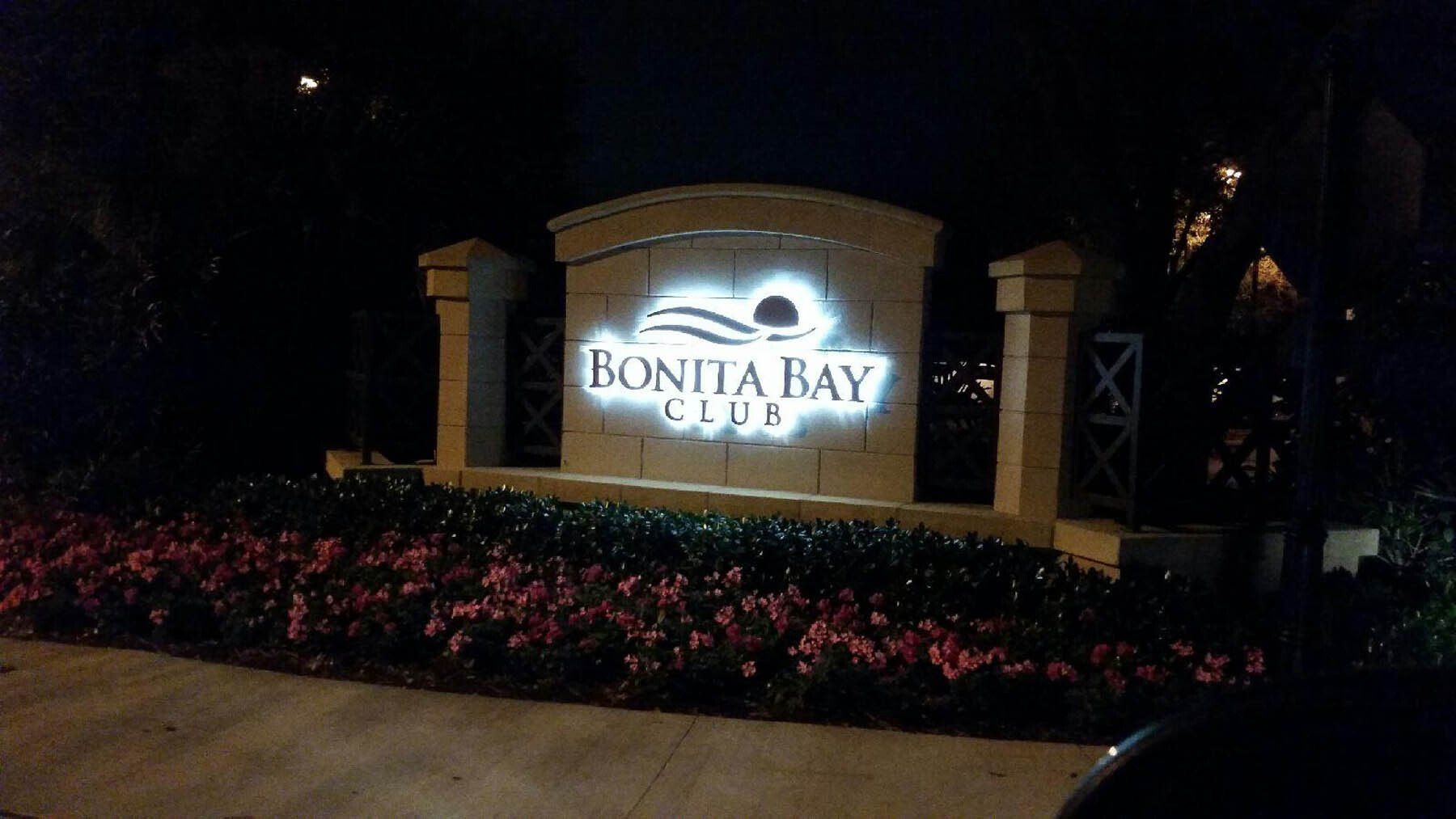 A monument sign for Bonita Bay Club at night, with reverse lit lettering.