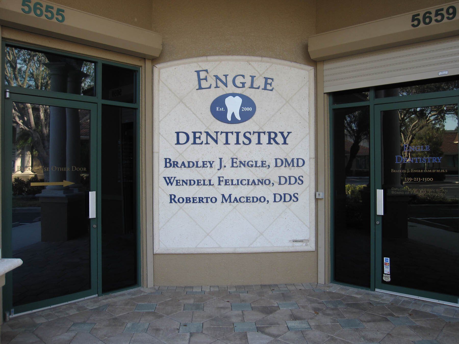 A sign for engle dentistry is on the side of a building
