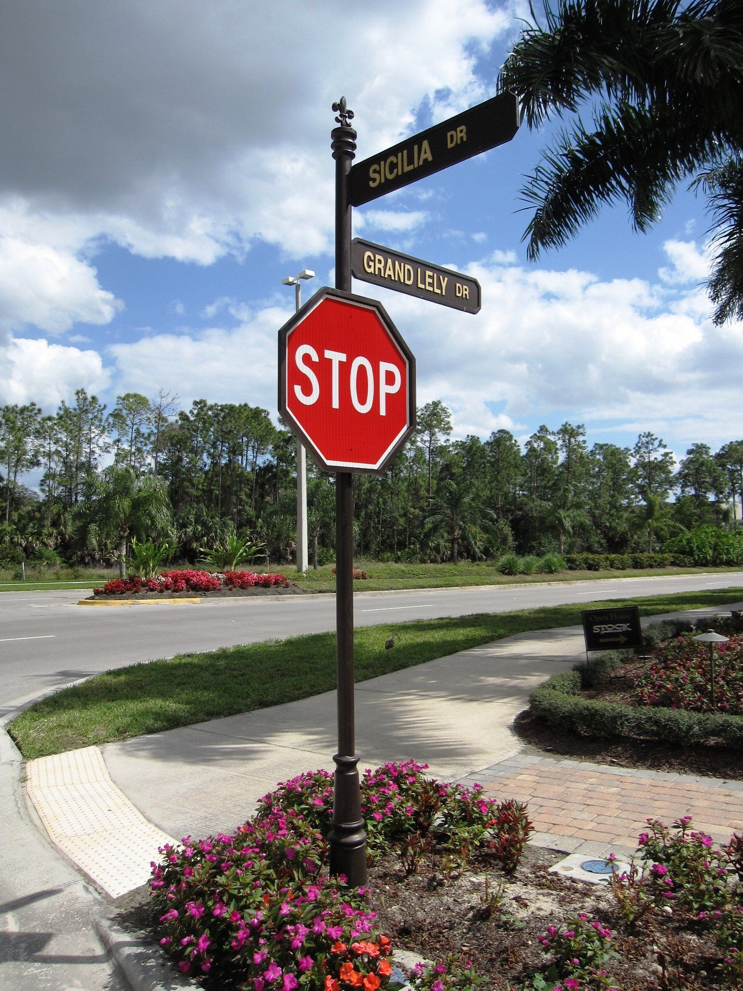 A stop sign is surrounded by flowers on the side of the road