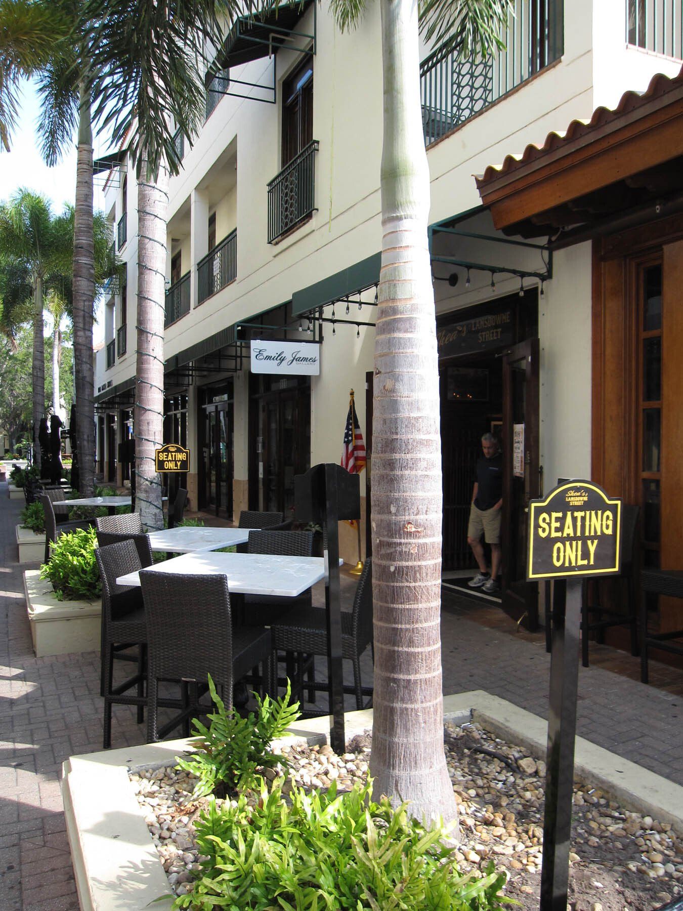 A street with tables and chairs and a sign that says 