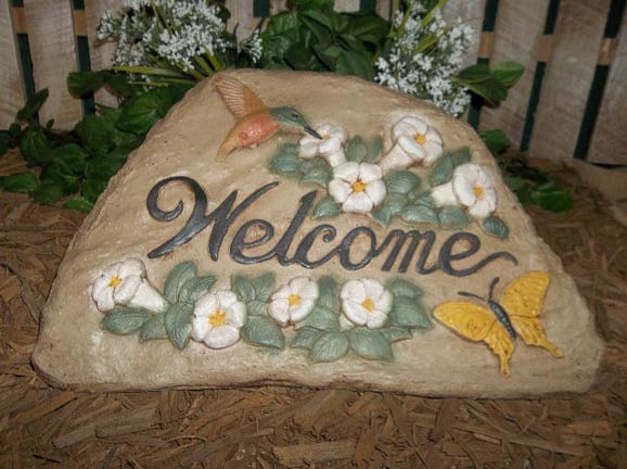 A welcome sign with flowers and butterflies on it