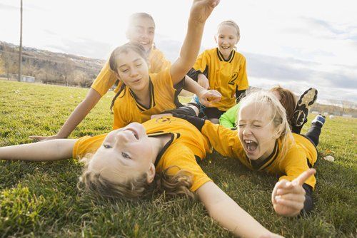 Excited soccer players celebrating on field