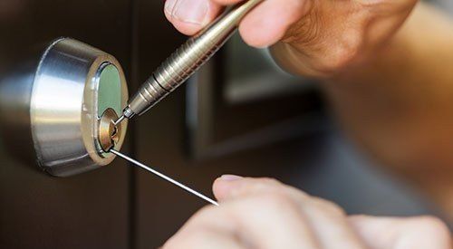 Residential Locksmith Using Picking Tools to Unlock Entry Door