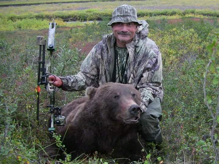 happy caribou and grizzly hunter with a arctic grizzly harvested with a bow