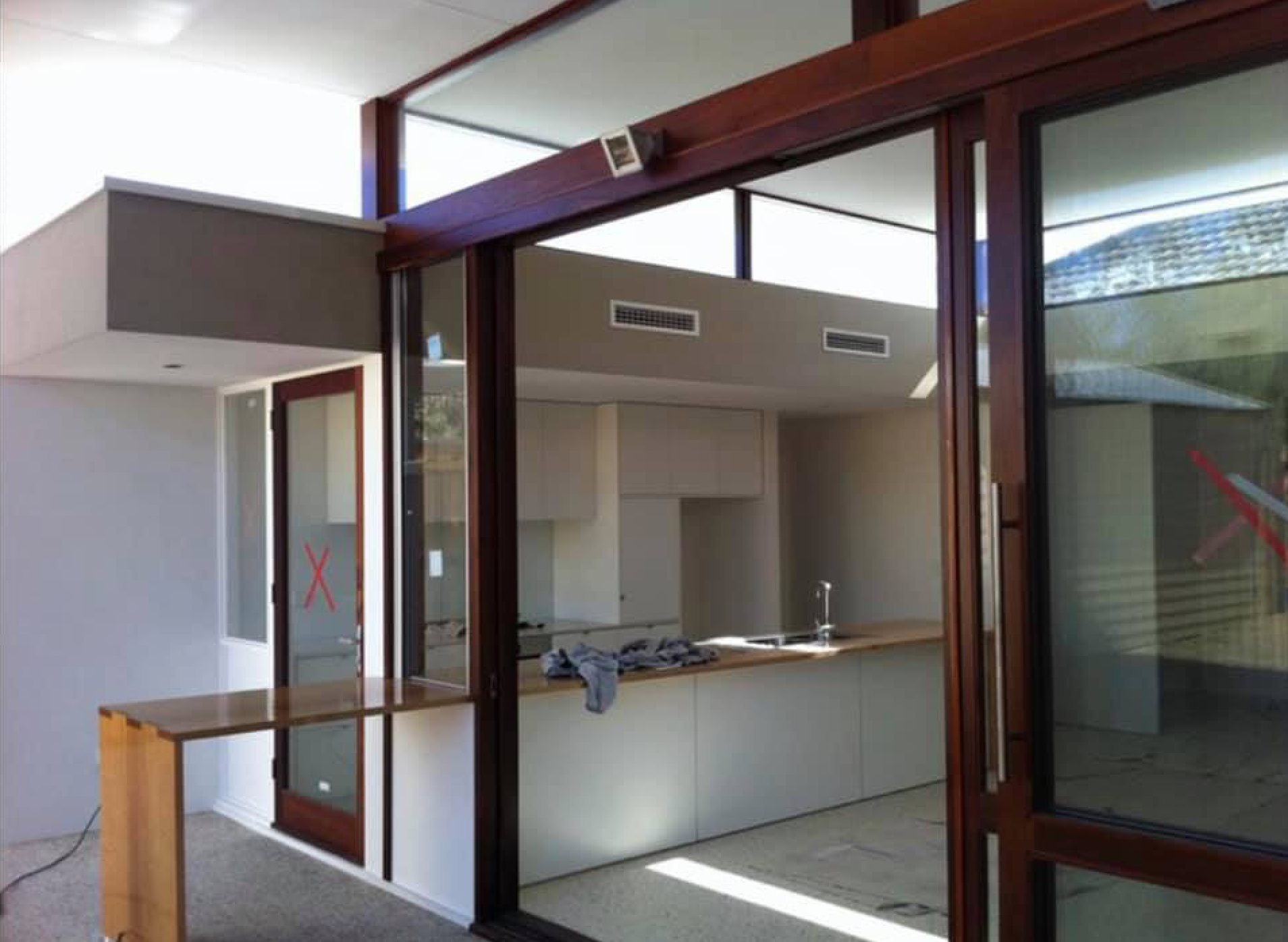 Modern kitchen interior with wood-framed glass walls and a central island under renovation