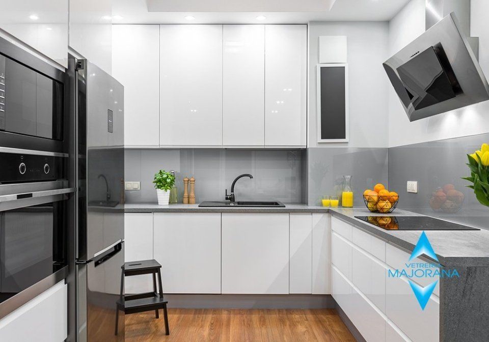 cucina bianca con rivestimenti in vetro