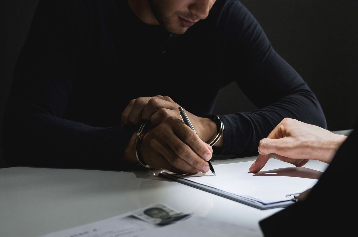 Criminal Law — Criminal Man with Handcuffs Signing Document in Bakersfield, CA