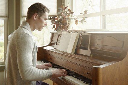 man learning to play the piano