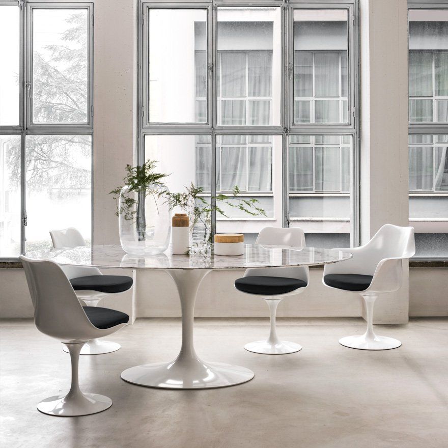 Ein Esszimmer mit einem Tisch und Stühlen vor einem Fenster