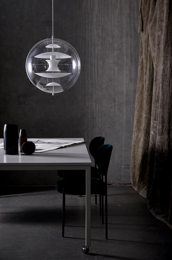 Ein Esszimmer mit einem Tisch und Stühlen und einer Lampe, die von der Decke hängt.