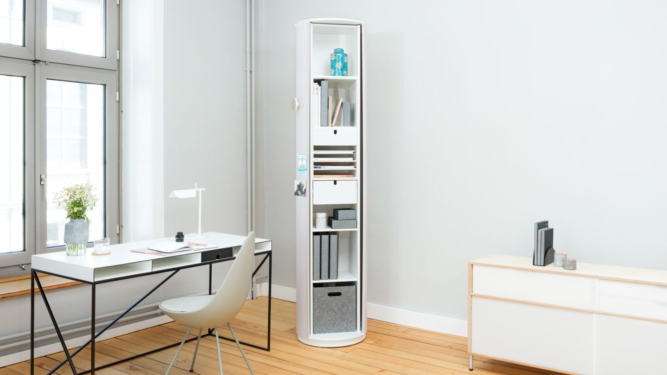 Ein Zimmer mit einem Schreibtisch, einem Stuhl und einem Bücherregal