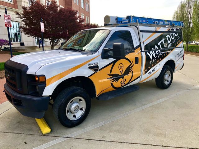 A white and yellow truck is parked in a parking lot.
