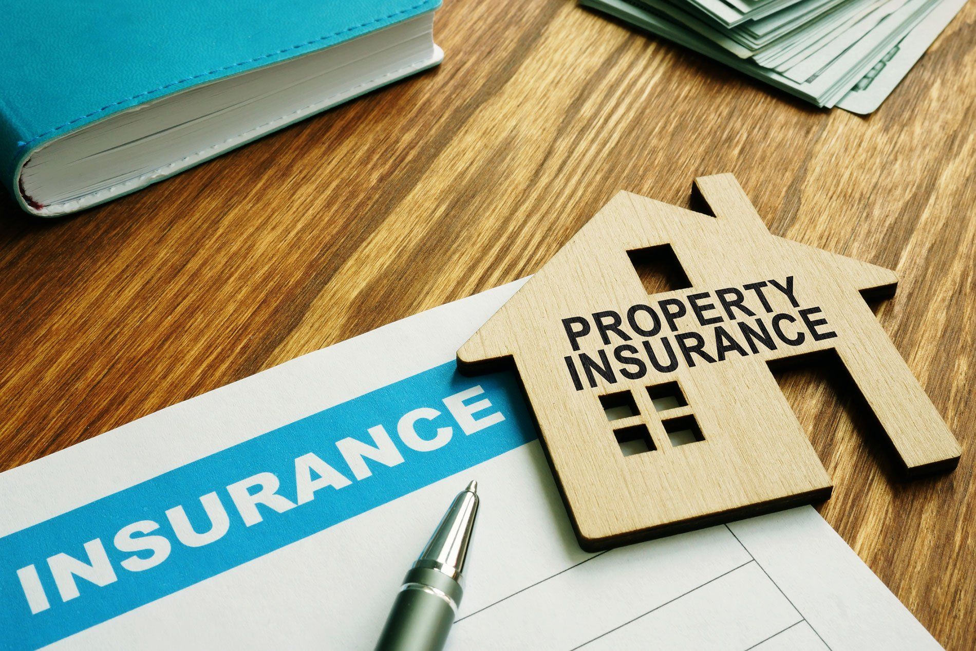 Property insurance stamp on a model wooden home.