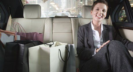 cheerful woman sitting with shopping bags