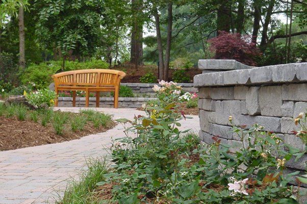 Closeup Of Flowers Behind Wooden Bench Next To Stone Wall — Virginia Beach, VA — Gentle Rain