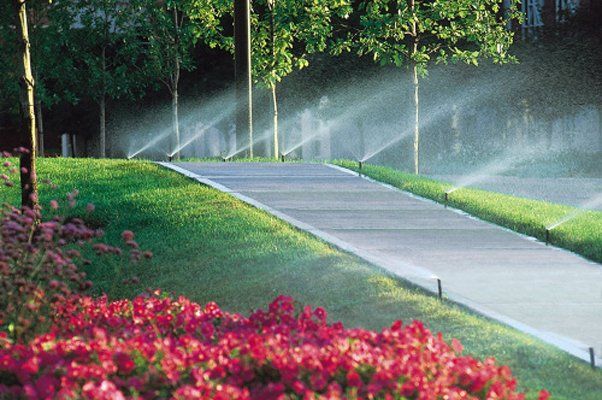 Multiple Sprinklers Spraying Water Next To Flower And Walkway — Virginia Beach, VA — Gentle Rain