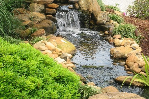 Nice Water Feature With Waterfall Next To Lush Bushes— Virginia Beach, VA — Gentle Rain