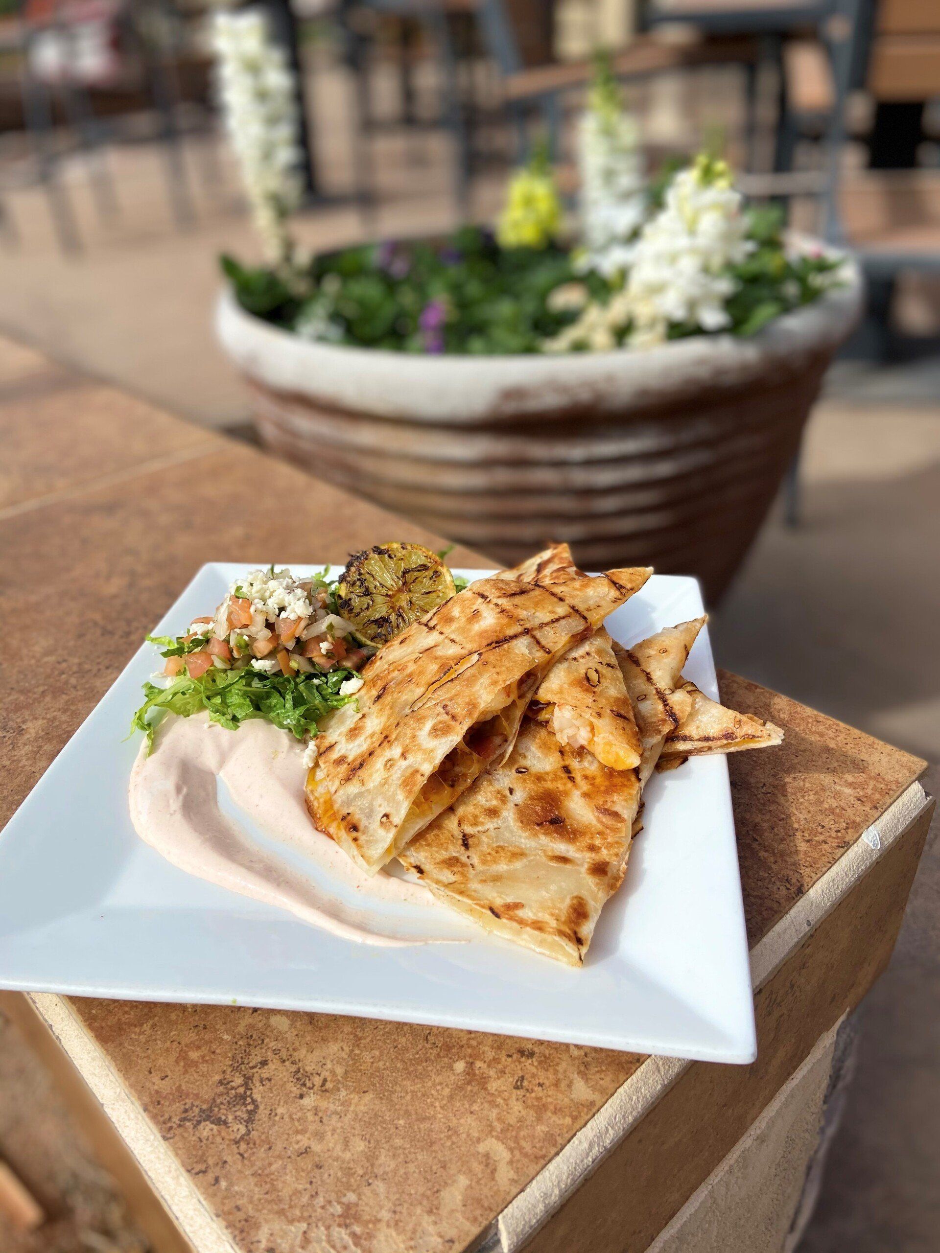 A plate of food is sitting on a table next to a potted plant.