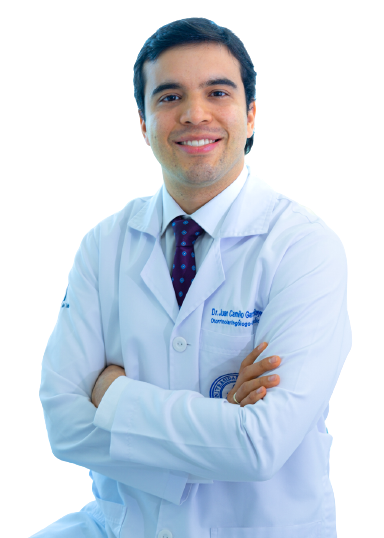 Médico sonriente con bata blanca, brazos cruzados y corbata, aislado en blanco.