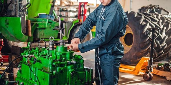 meccanico al lavoro su un motore verde
