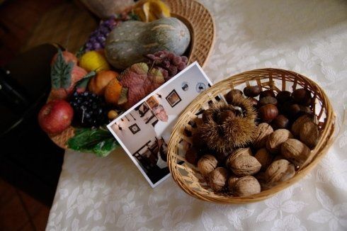 due cestini di frutte e noci e una foto di uomo
