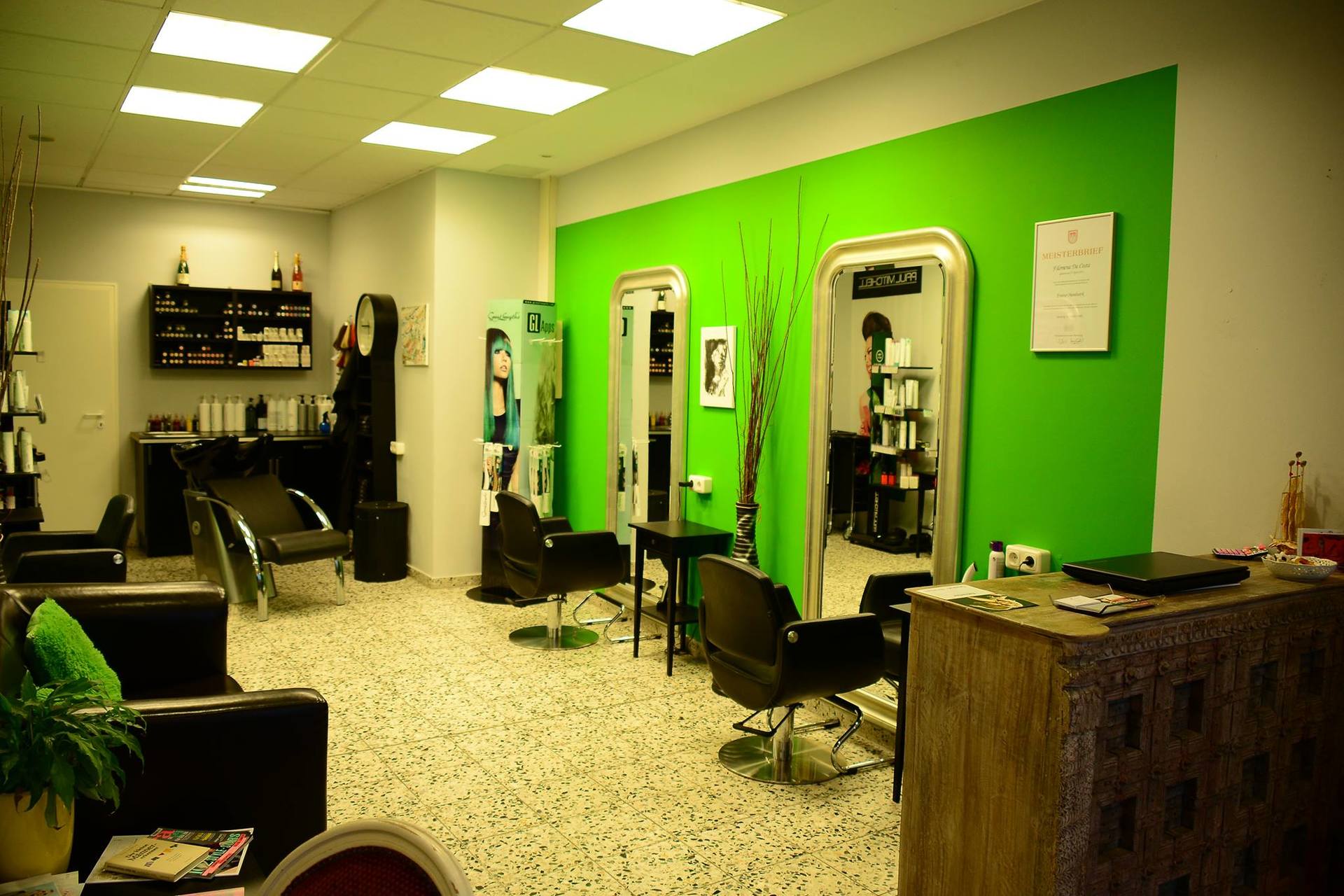 Ein Friseursalon mit grünen Wänden und Stühlen