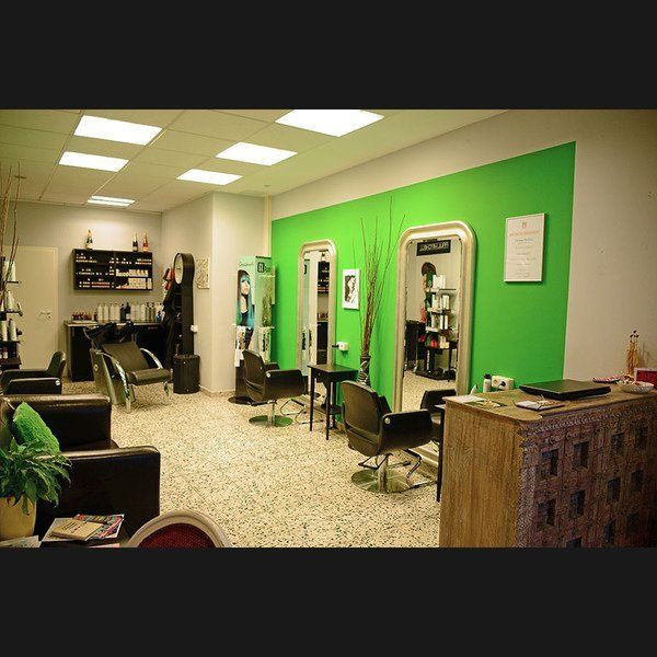 Ein Friseursalon mit grünen Wänden und Stühlen