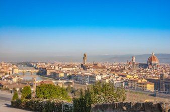 Panoramisch uitzicht over Florence (Italië), met gebouwen, bruggen en de Duomo onder een helderblauwe hemel.