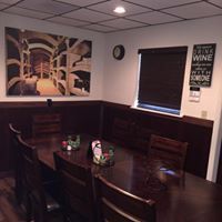 A long wooden table in a room with artwork and a 