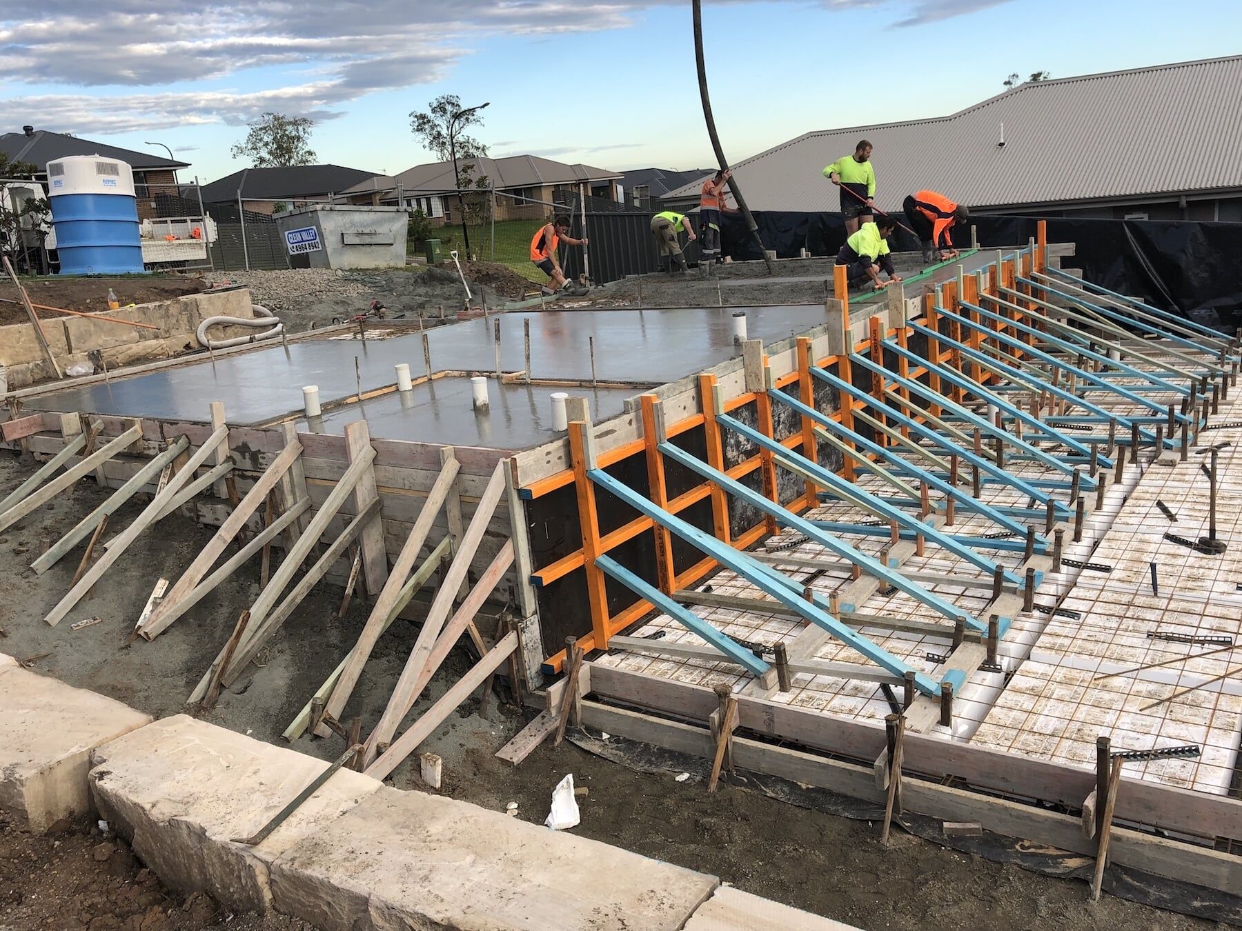 Workers Pouring And Levelling Concrete — Concreting in Tanilba Bay, NSW Workers Pouring And Levelling Concrete — Concreting in Tanilba Bay, NSW