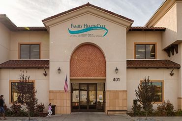 Family Healthcare clinic exterior with arched entryway and American flag.