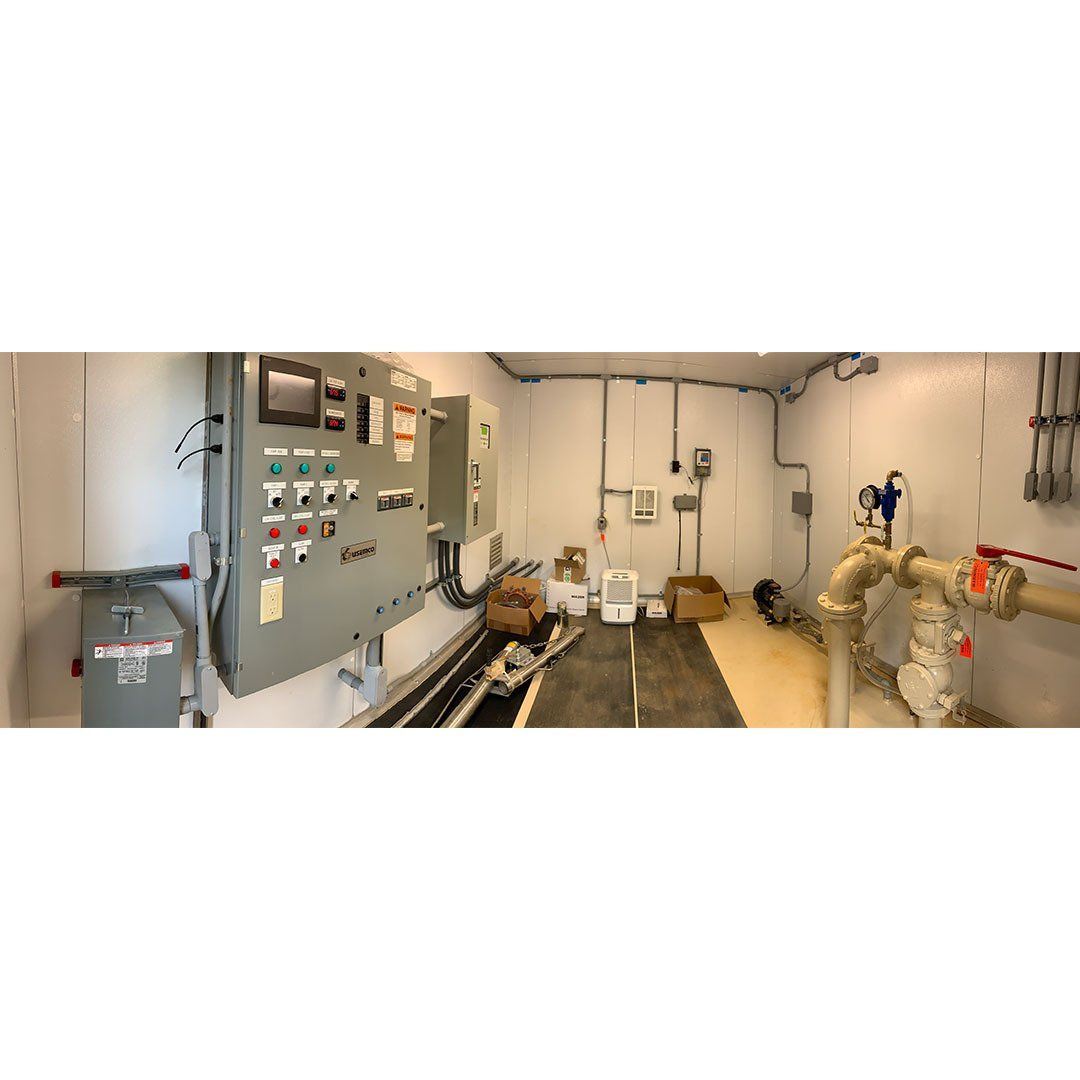 A room with a lot of electrical equipment and pipes.