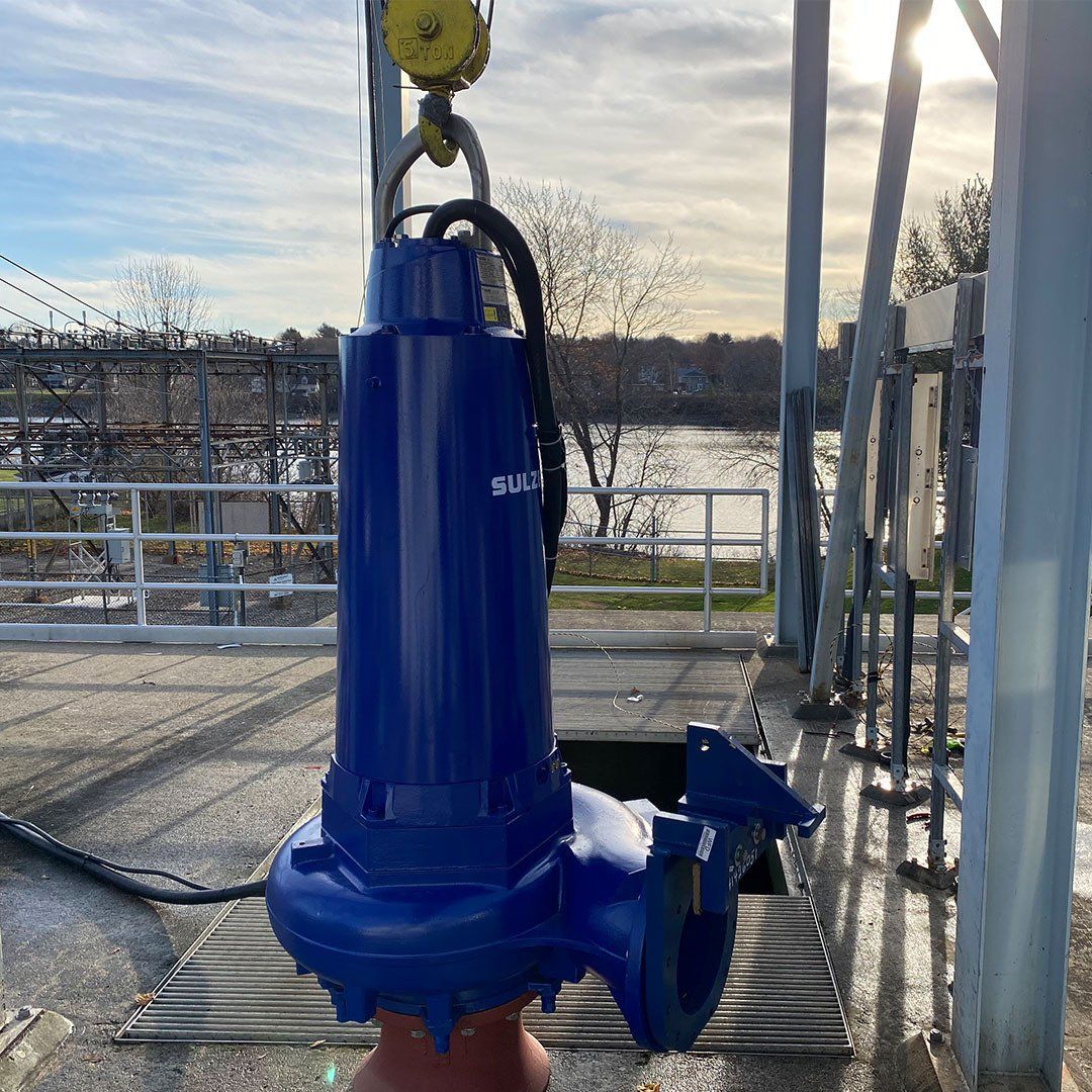 A large blue pump is sitting on top of a concrete surface.