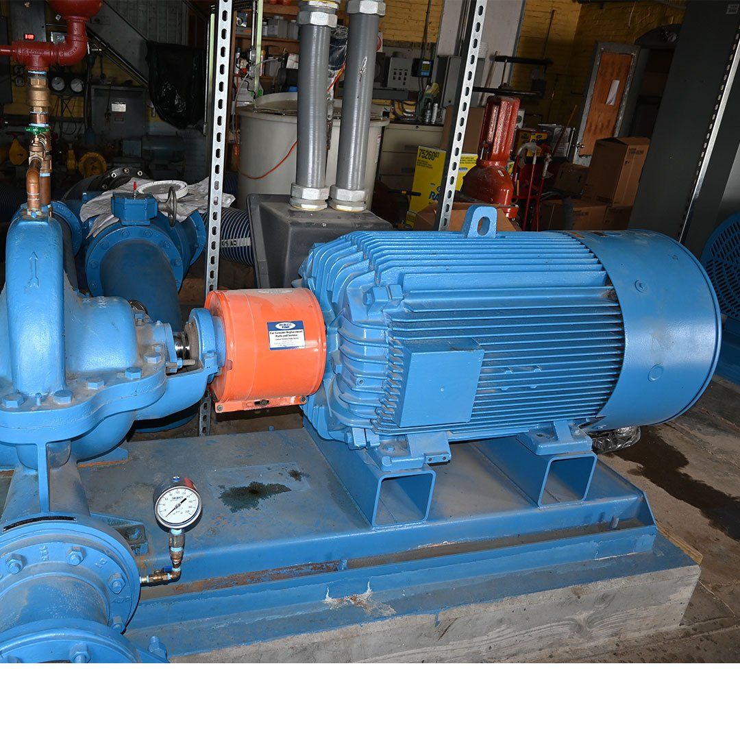 A large blue motor is sitting next to a pump