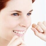 Woman using dental floss — Dental floss in Cheyenne, WY